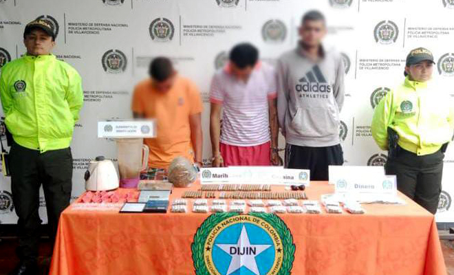 Personas capturadas-policías custodiando