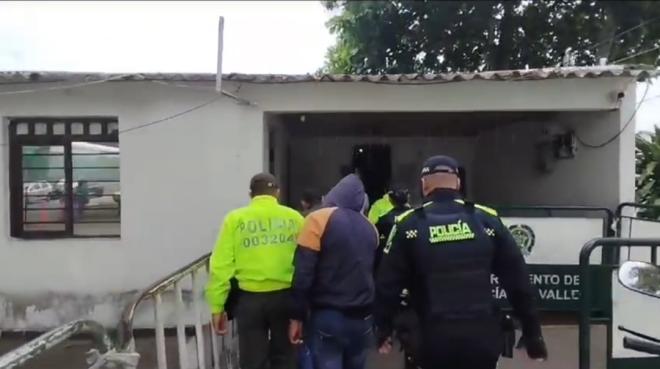 Personas capturadas-policías custodiando