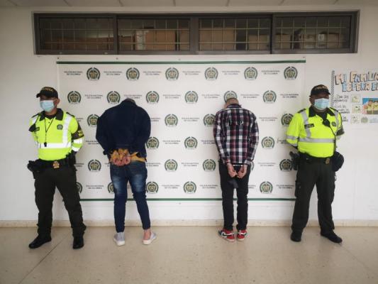 Personas capturadas-policías custodiando