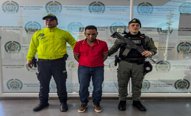 Dos policias con un hombre capturado en el medio
