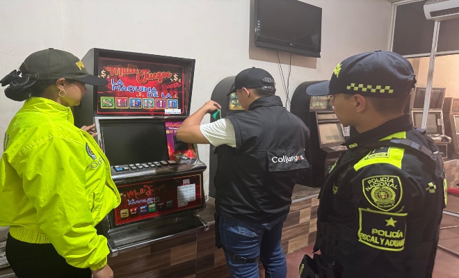 Personal de la direccion de Policia Fiscal y aduanera incautando la maquina de juegos de azar