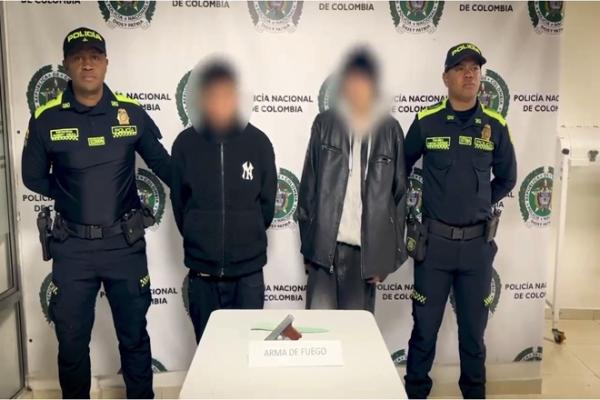dos capturados en el centro de la foto y dos polic&iacute;as a los costados