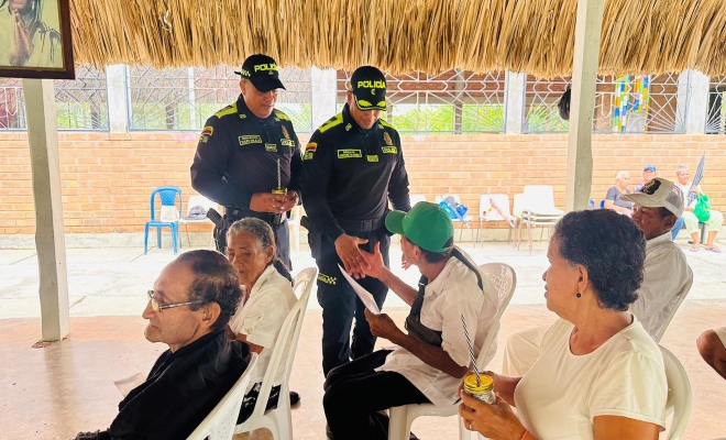 dos uniformados haciendo entrega de diplomas a varios ciudadanos 