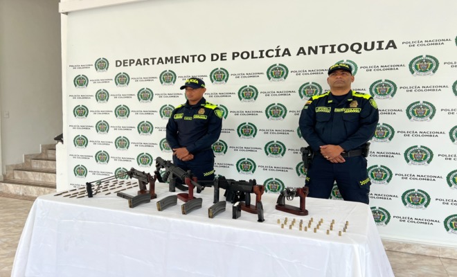 Dos policias custodian fusiles, provedores y munición incautada
