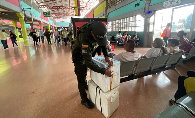 policía realizando registro a encomiendas en terminal de transporte