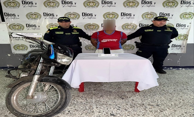 Dos polic&iacute;as con un capturado y una motocicleta