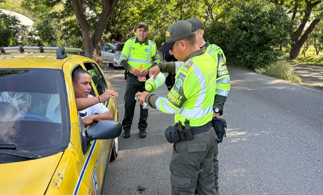 Funcionarios policiales de tránsito entregando café y pan a actores viales