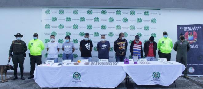 Personas capturadas-policías custodiando