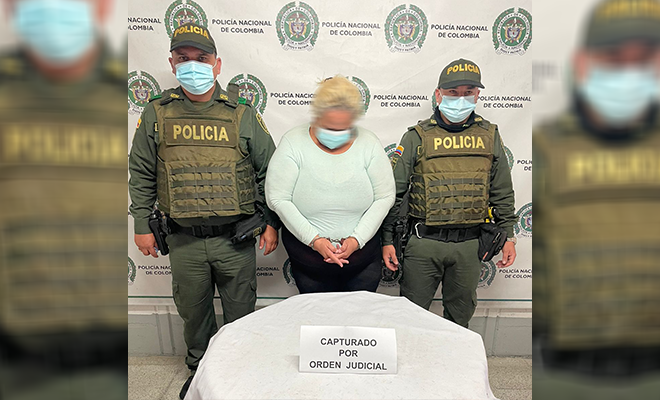 Policías custodian a mujer capturada por orden judicial en Medellín