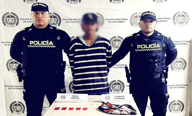 Dos policías y un capturado junto a el material incautado
