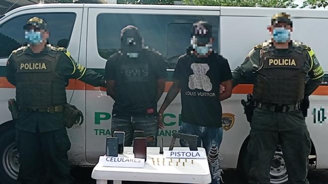 2 personas capturadas-policías custodiando
