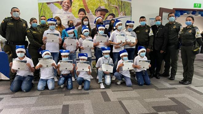 niños recibiendo diploma- policías acompañando