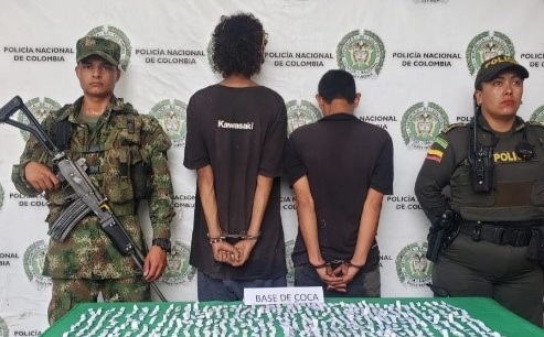 Personas capturadas-policías custodiando