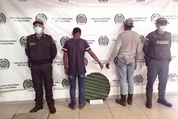 Dos personas capturas-policías custodiando-elementos incautados