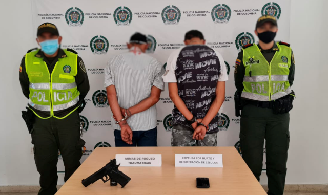 2 personas capturadas-policías custodiando