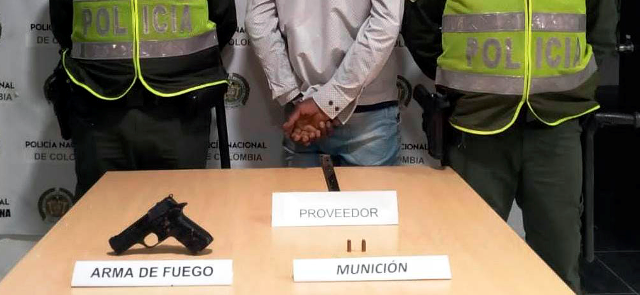 Persona capturada- policías custodiando-arma de fuego-munición 