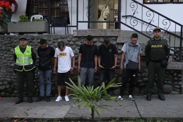 Personas capturadas-policías custodiando 