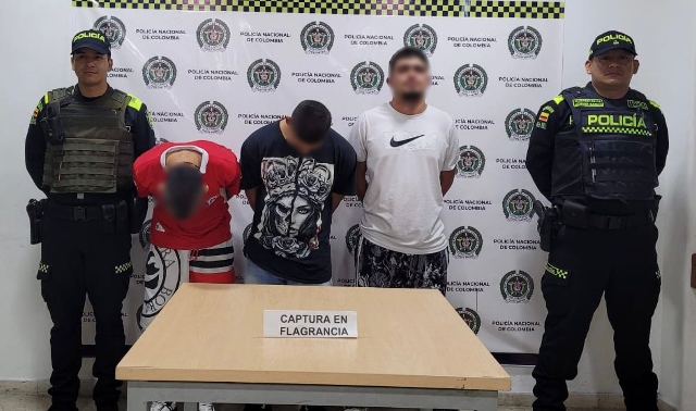 Personas capturadas-policías custodiando