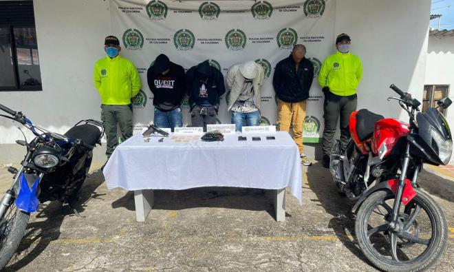 Personas capturadas-policías custodiando