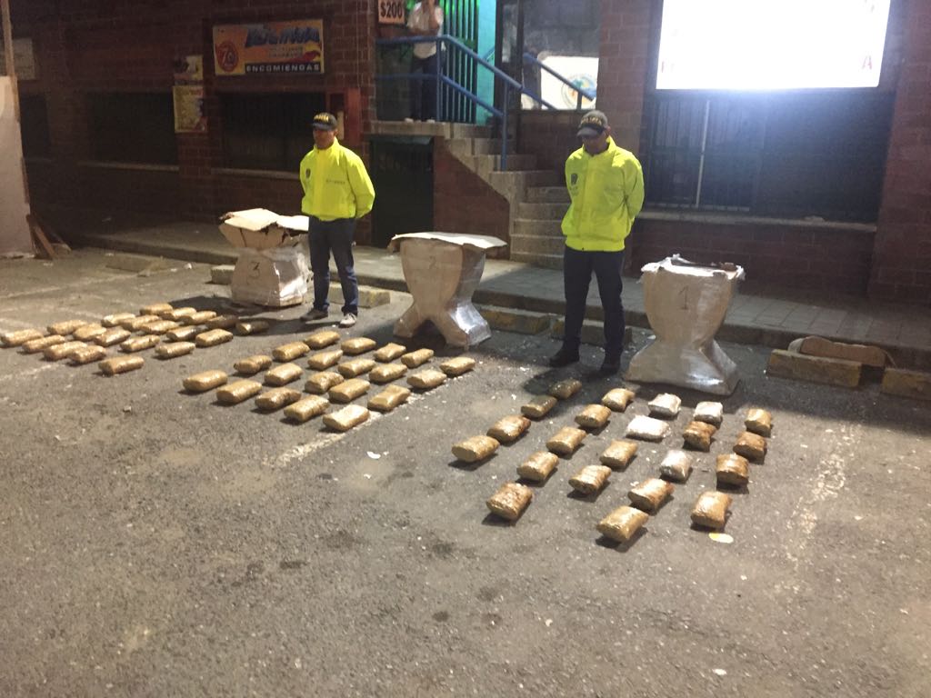 Dos policías de la Sijin custodian pacas de marihuana