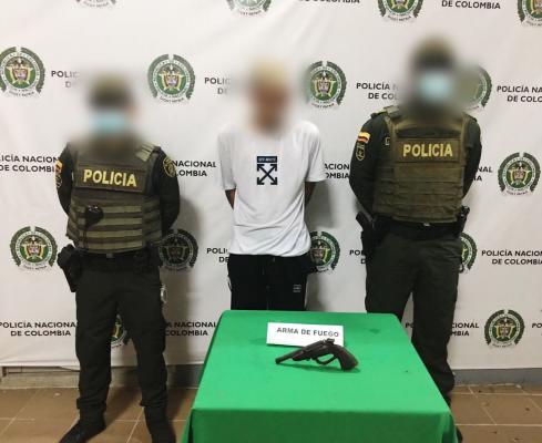 Una persona capturada-policías custodiando-arma de fuego incautada