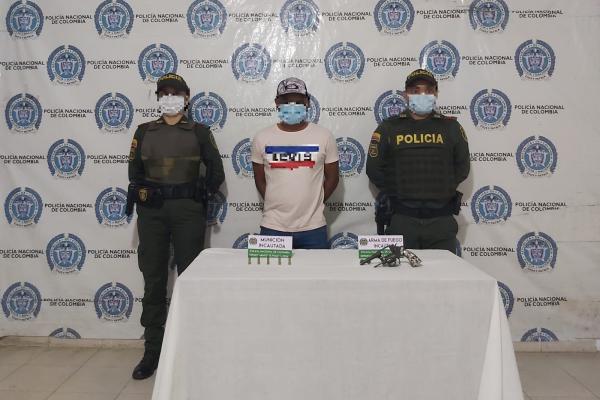 Una persona capturada-policías custodiando-arma de fuego incautada