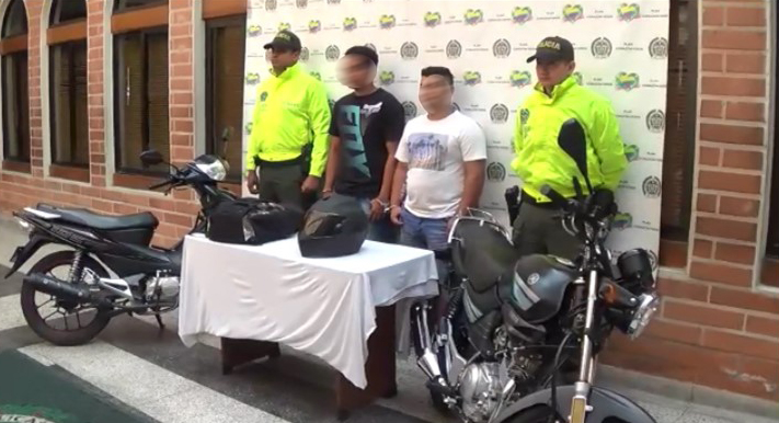 Dos personas capturadas custodiados por dos policías de la Sijin 