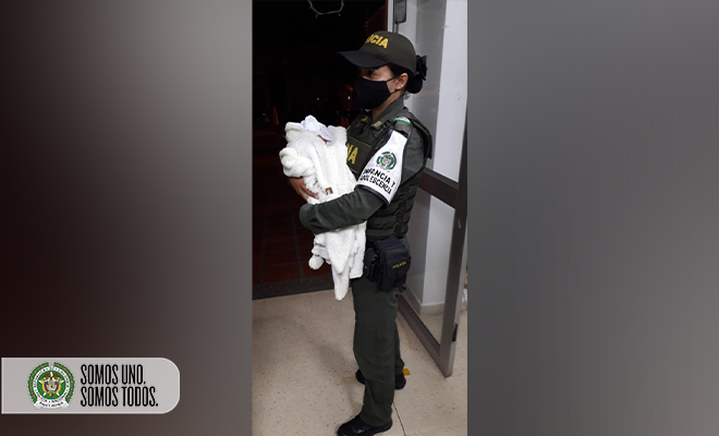 policía sosteniendo a bebe rescatado