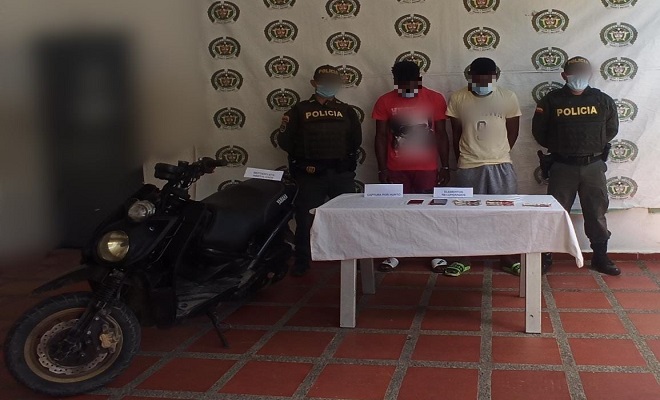 dos personas capturadas-policías custodiando-motocicleta inmovilizada